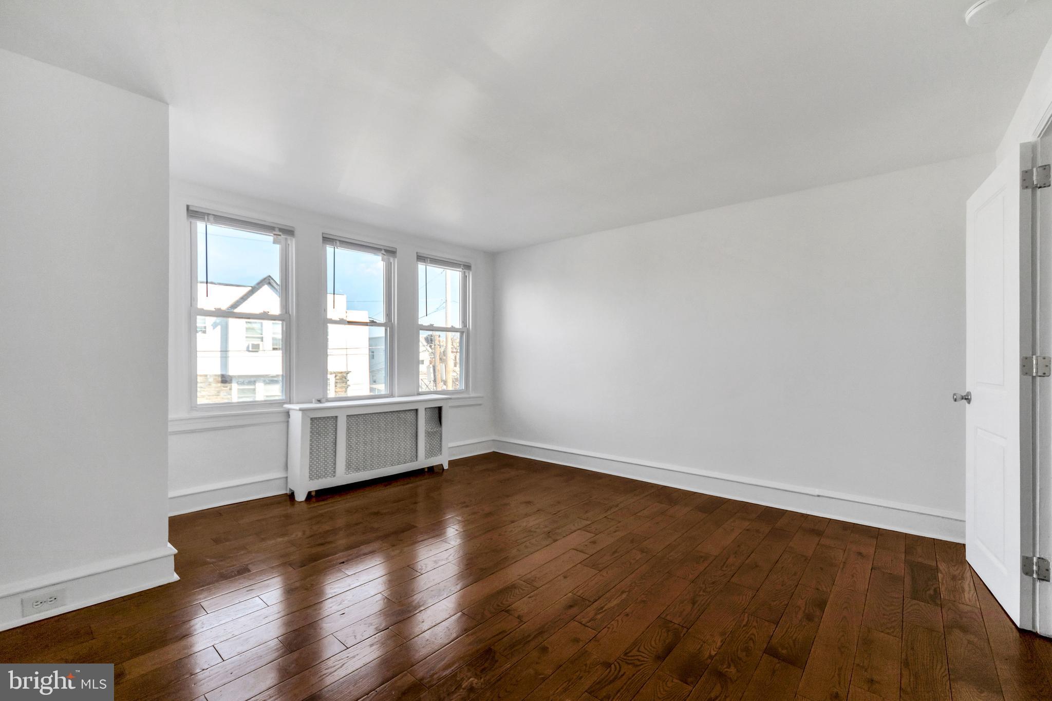 196 Springton Road Upper Darby, PA 19082 - Photo 14 of 27 an empty room with wooden floor and windows
