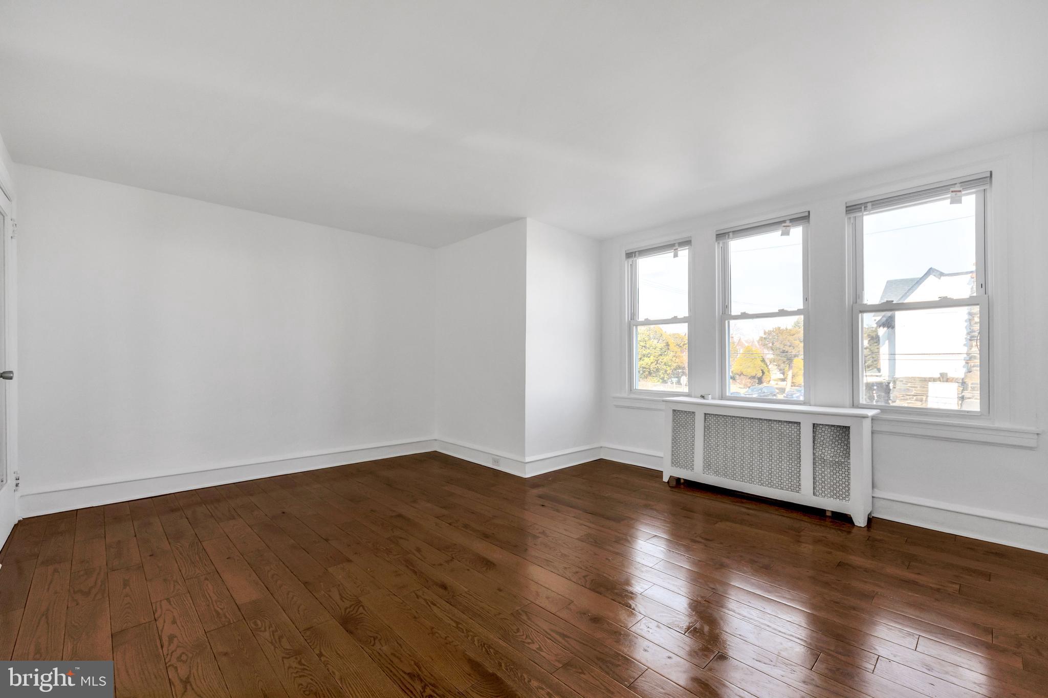 196 Springton Road Upper Darby, PA 19082 - Photo 15 of 27 an empty room with wooden floor and windows