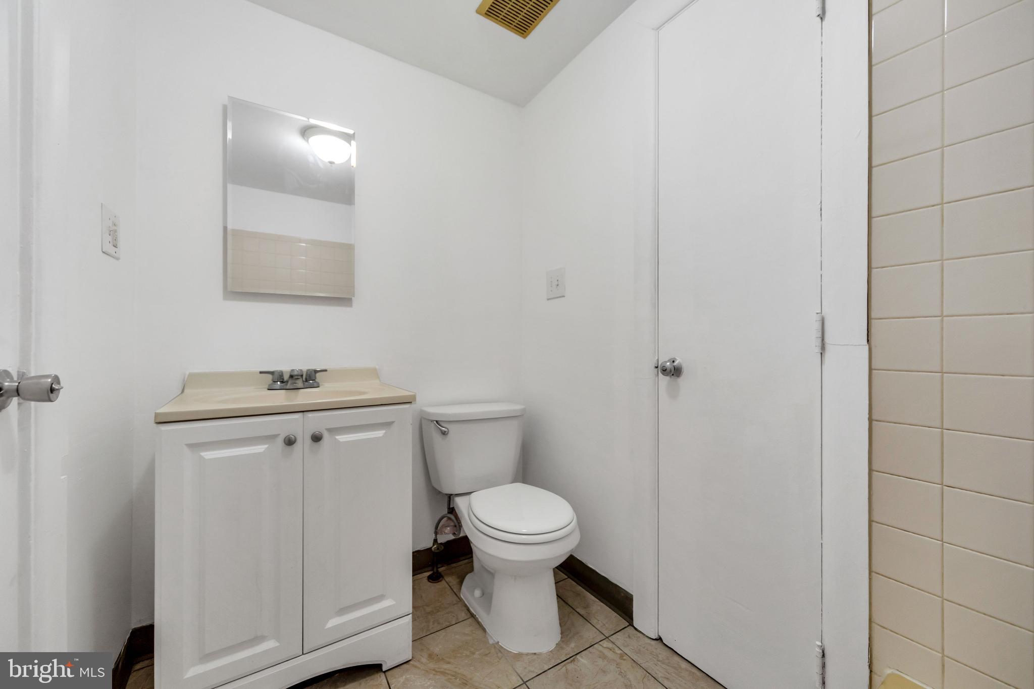 196 Springton Road Upper Darby, PA 19082 - Photo 18 of 27 a bathroom with a toilet a sink and mirror