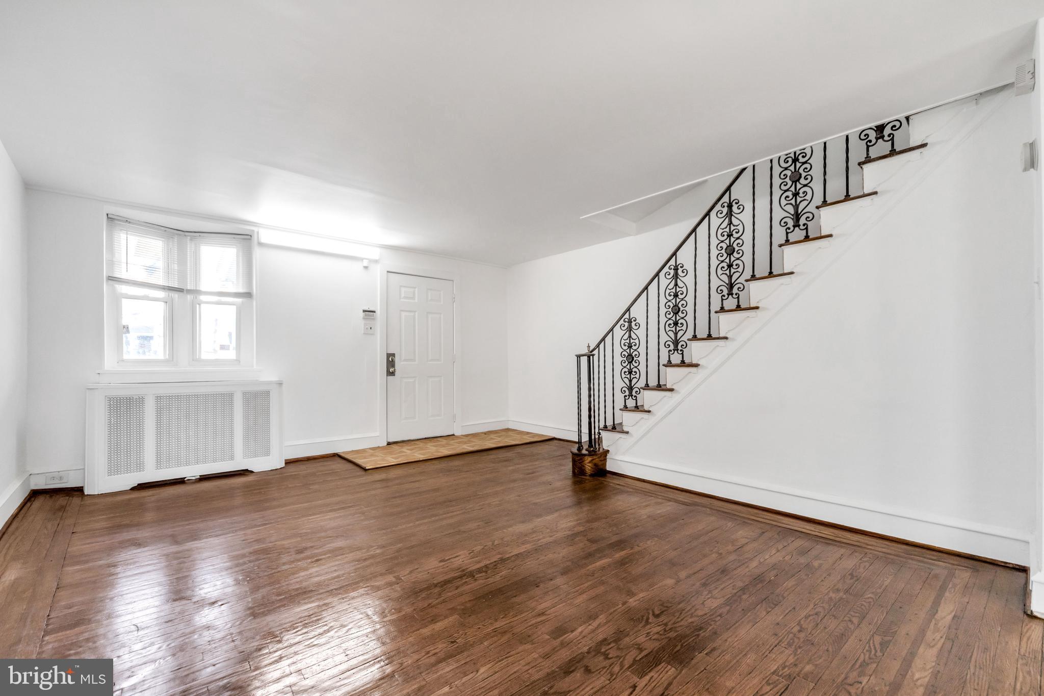 196 Springton Road Upper Darby, PA 19082 - Photo 6 of 27 a view of an empty room with wooden floor and stairs