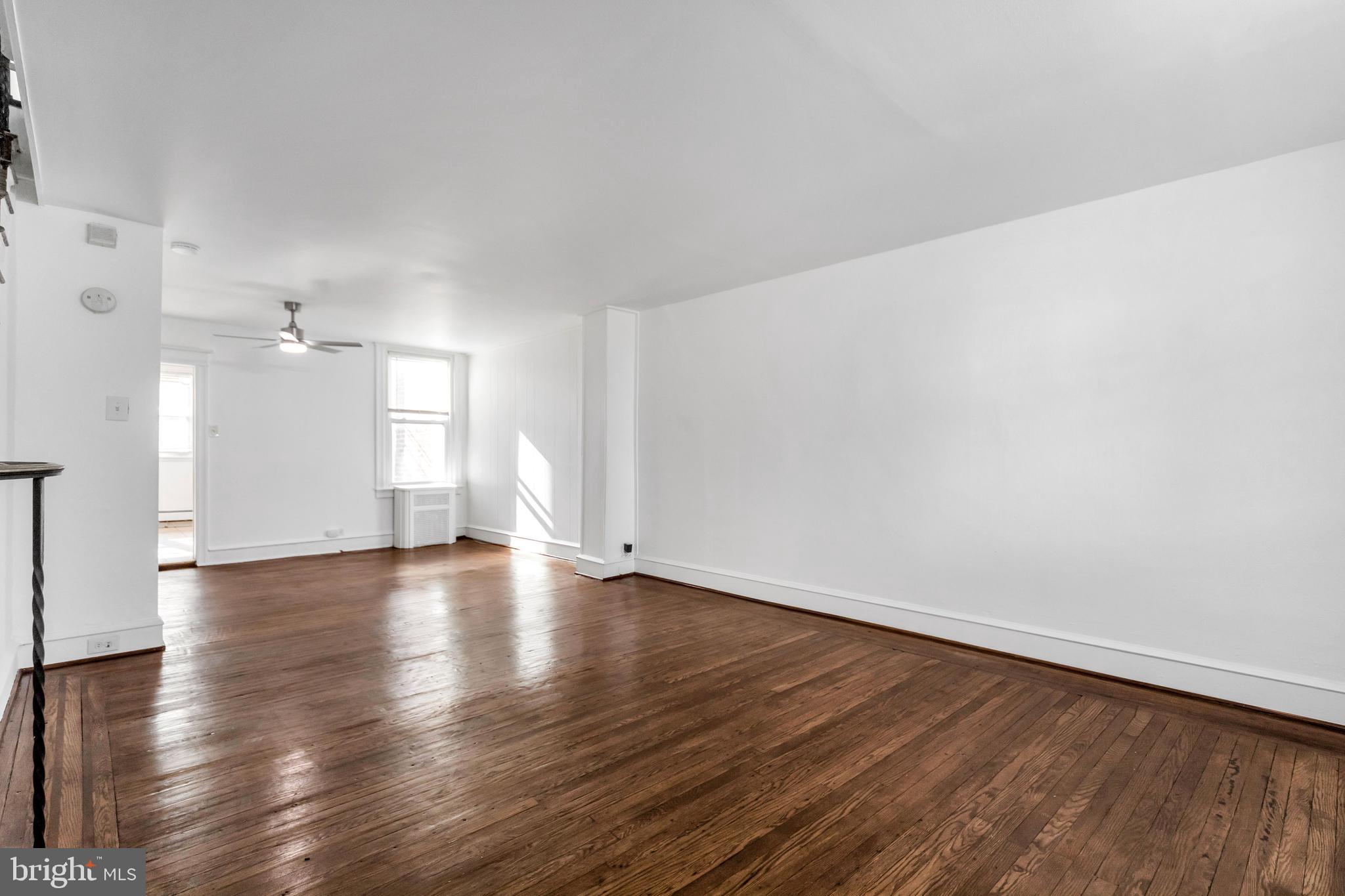 196 Springton Road Upper Darby, PA 19082 - Photo 7 of 27 a view of an empty room with wooden floor and a window
