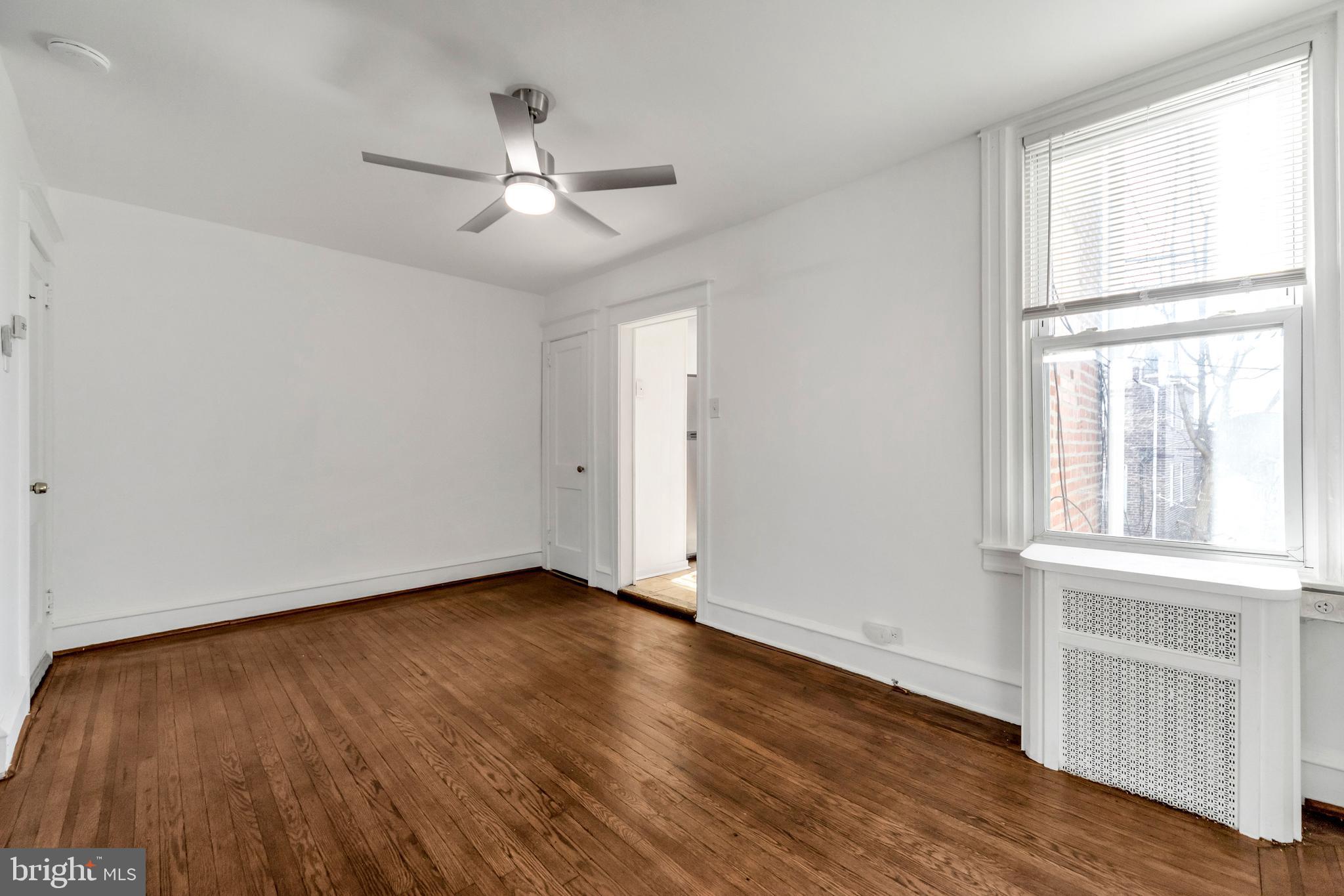 196 Springton Road Upper Darby, PA 19082 - Photo 8 of 27 an empty room with wooden floor chandelier fan and windows