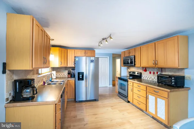 a kitchen with stainless steel appliances a refrigerator sink and cabinets