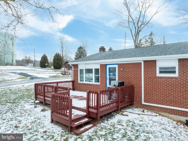 a view of a house with a wooden deck and furniture