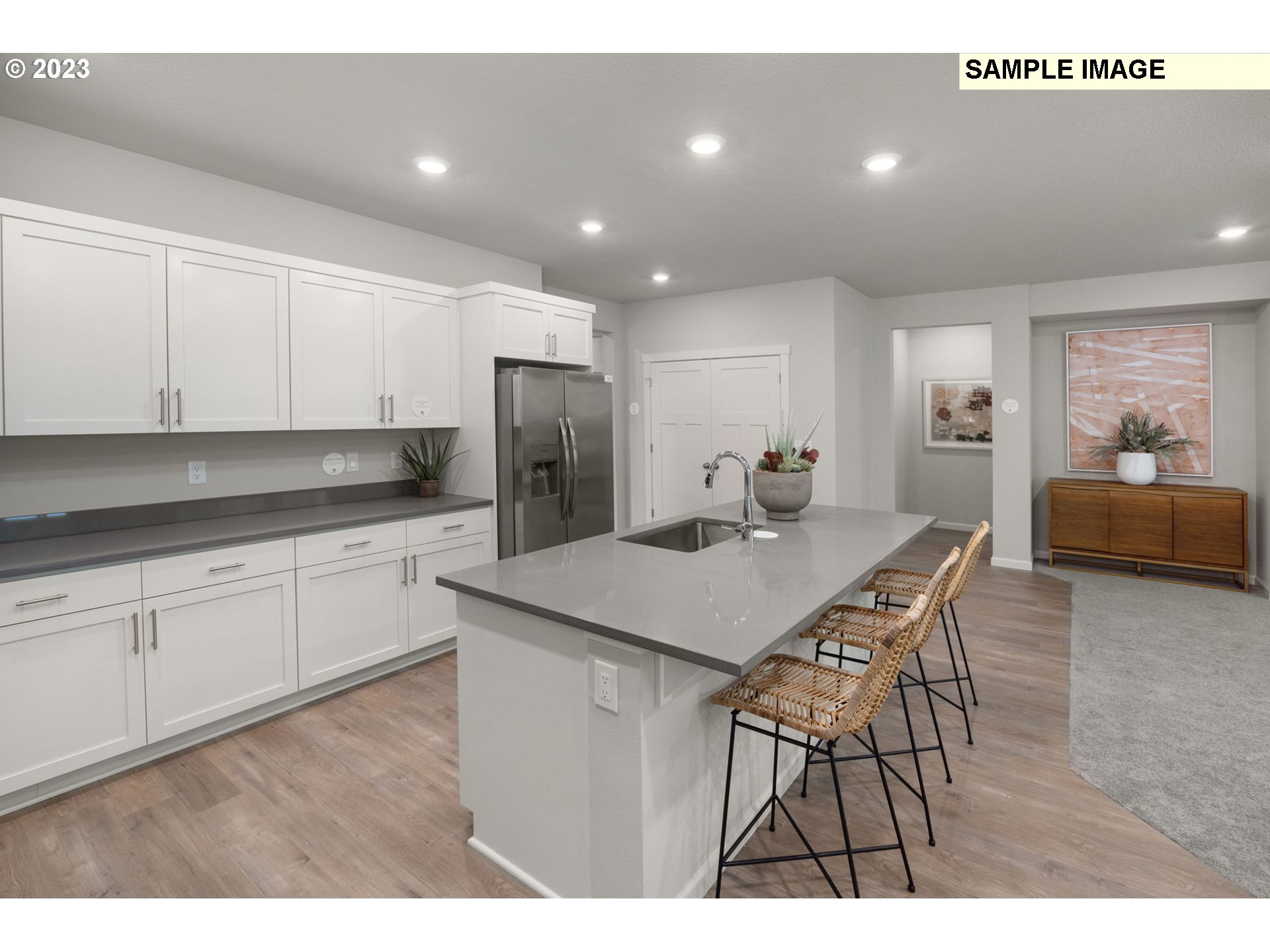 2364 Southeast Teal Avenue Gresham, OR 97080 - Photo 4 of 20 a kitchen with stainless steel appliances kitchen island a table chairs in it and white cabinets