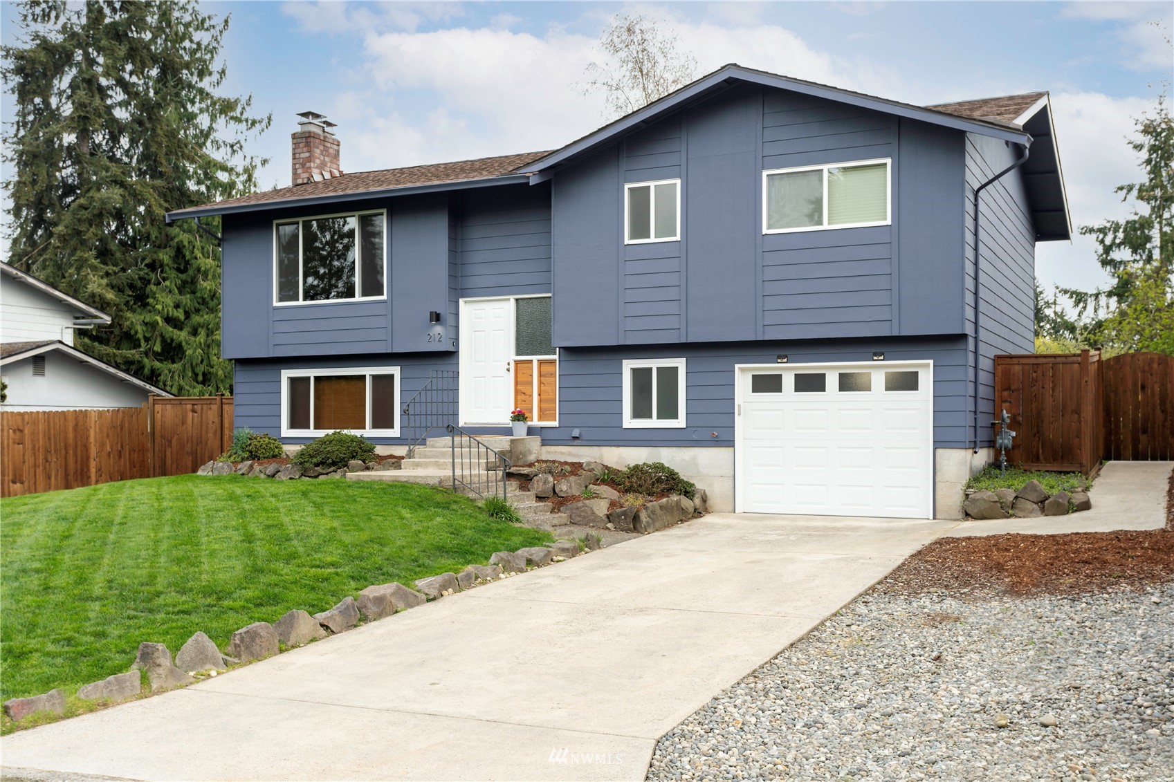 212 225th Street Southwest Bothell, WA 98021 - Photo 3 of 31 a front view of a house with a yard and garage