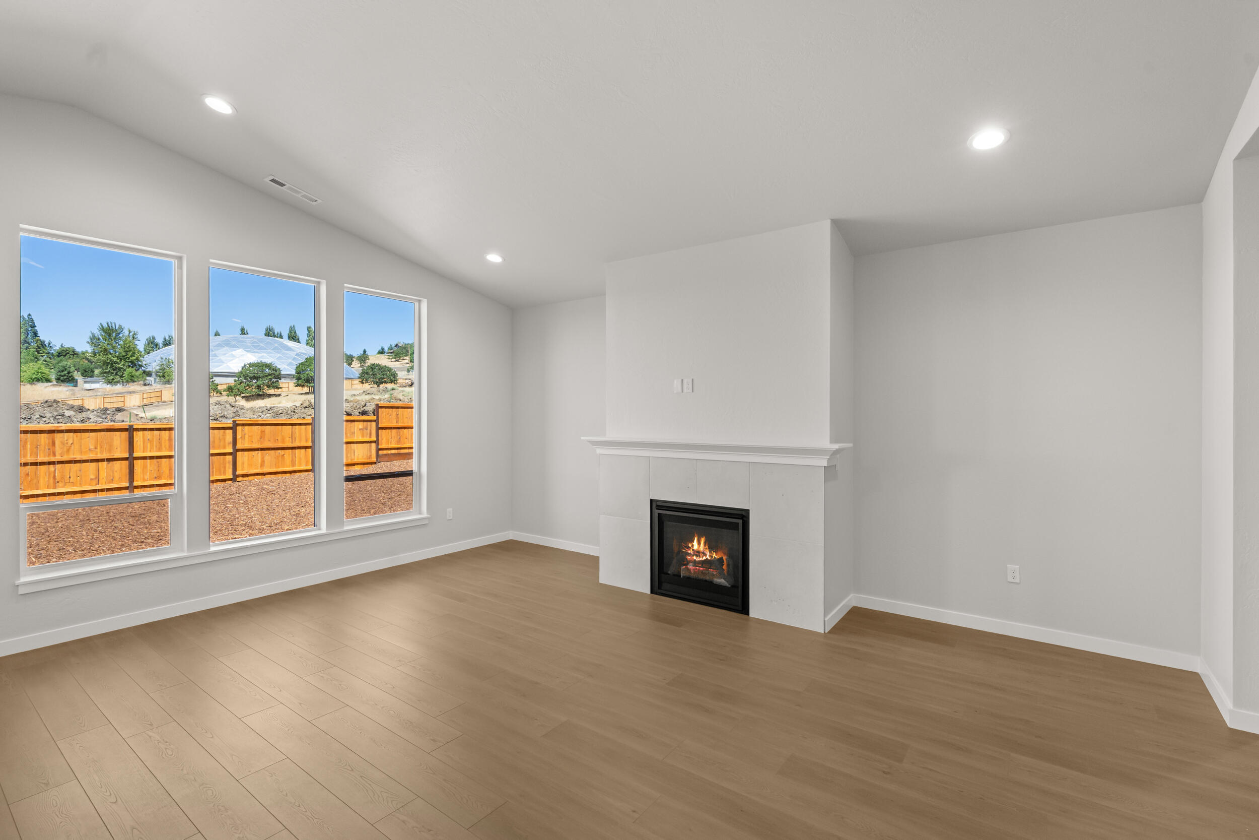 1141 Pumpkin Ridge, Unit 320 Eagle Point, OR 97524 - Photo 10 of 25 an empty room with wooden floor fireplace and windows