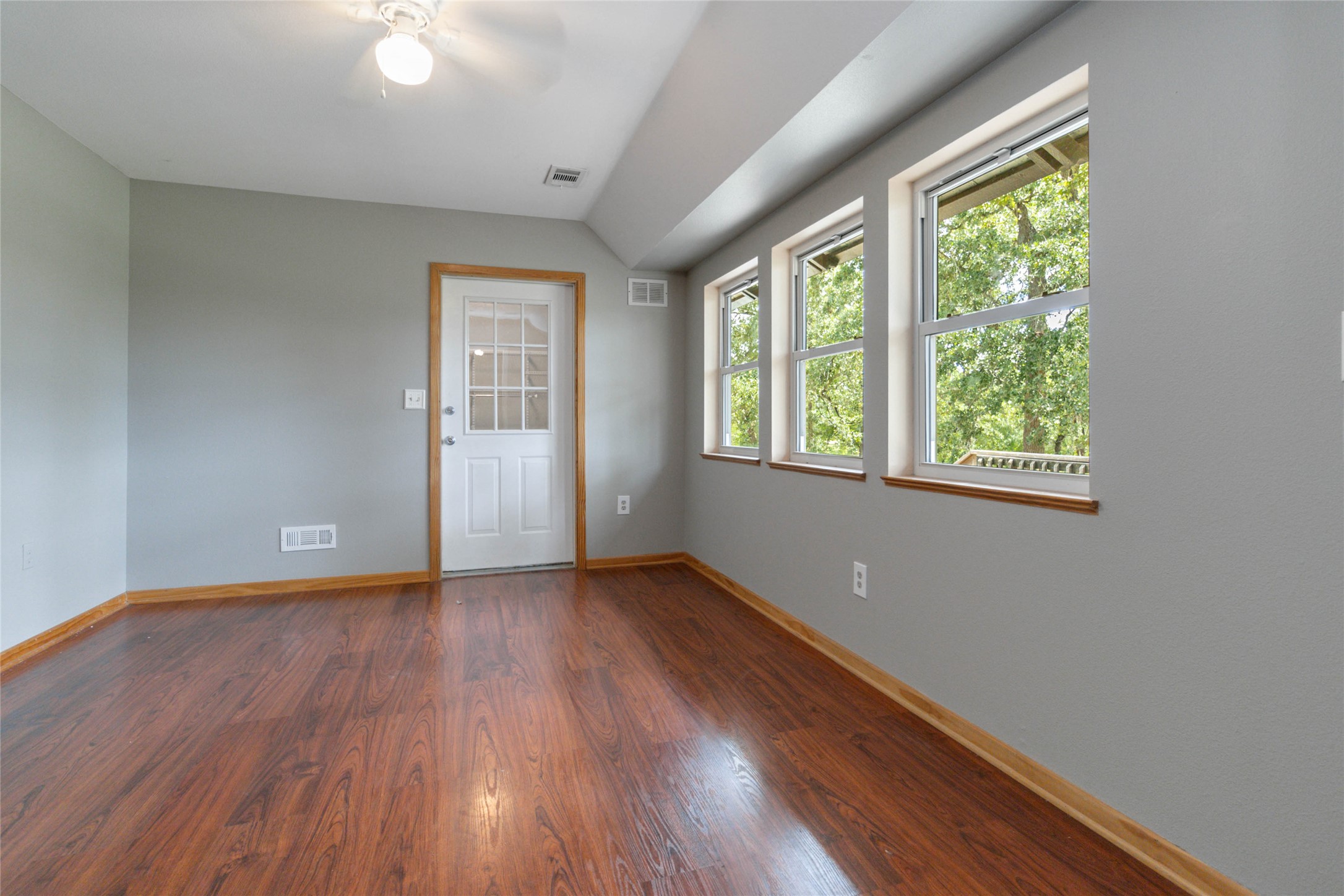180 Ironstone Road Smithville, TX 78957 - Photo 7 of 37 Unfurnished room featuring dark wood-style floors, lofted ceiling, and a ceiling fan