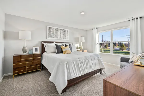 a bedroom with a large bed and a flat tv screen on dresser