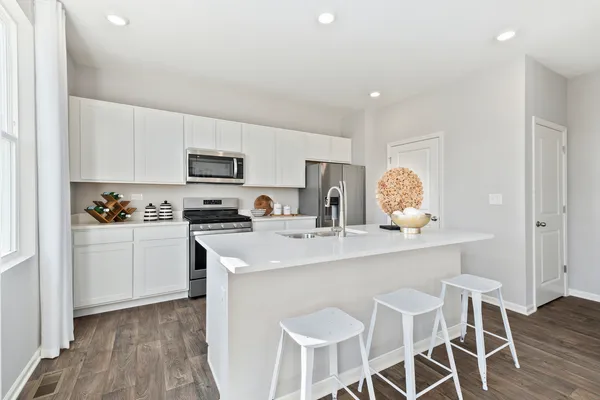 a kitchen with granite countertop white cabinets and stainless steel appliances