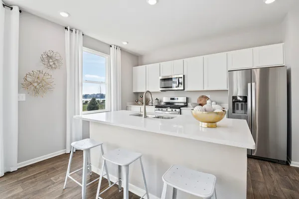 a kitchen with a sink a refrigerator and wooden floor