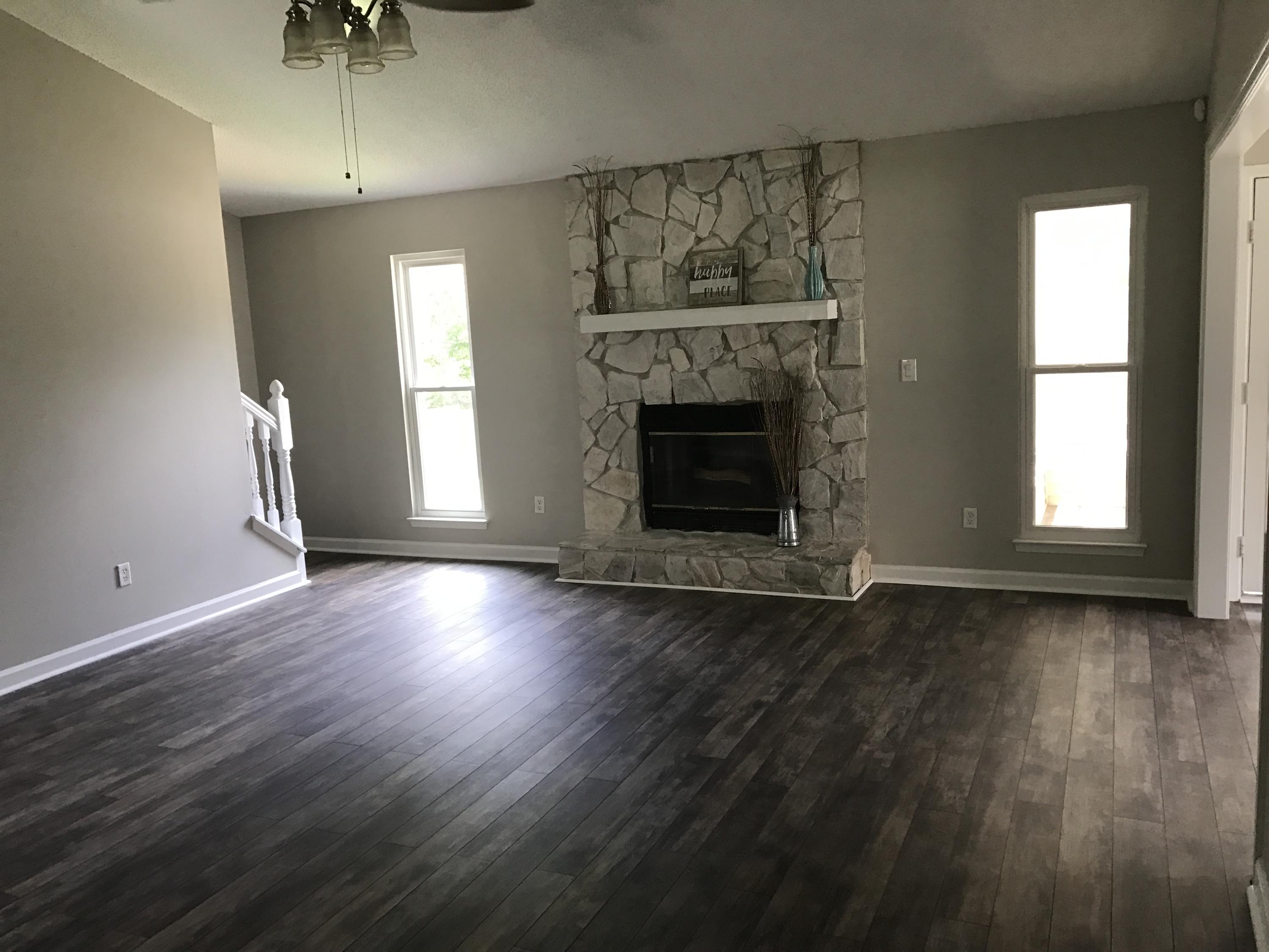2839 Old Mill Way Crestview, FL 32539 - Photo 9 of 28 an empty room with wooden floor a fireplace and windows