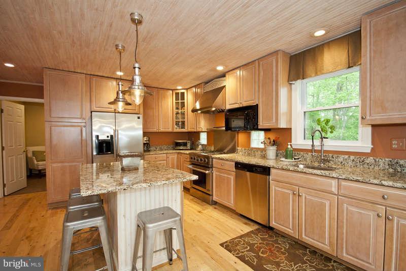 115 Houck Road Westminster, MD 21157 - Photo 9 of 30 a kitchen with stainless steel appliances granite countertop a sink a stove a refrigerator cabinets and chairs