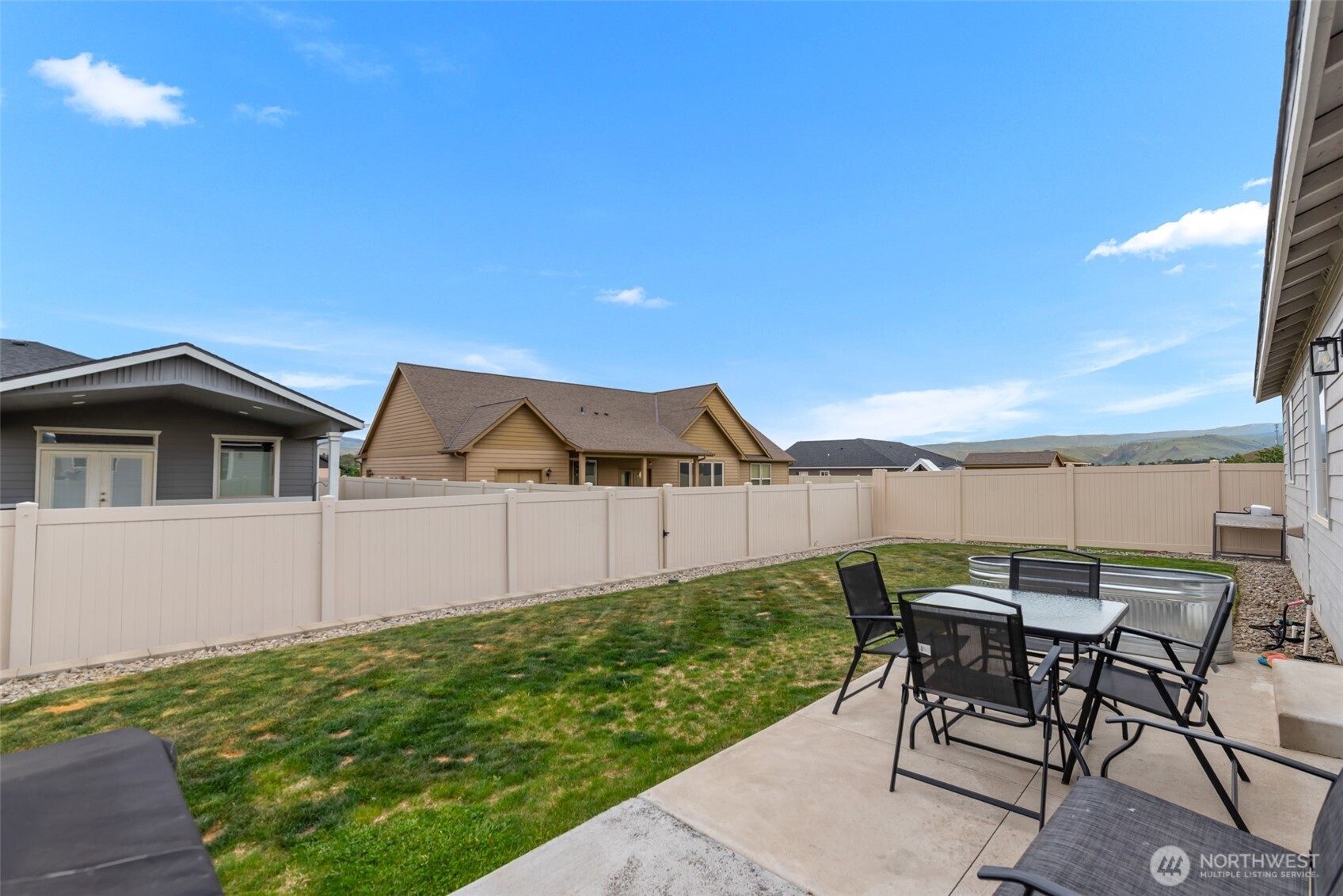 282 Emma Drive Wenatchee, WA 98801 - Photo 30 of 38 a view of a patio with table and chairs under an umbrella next to a yard