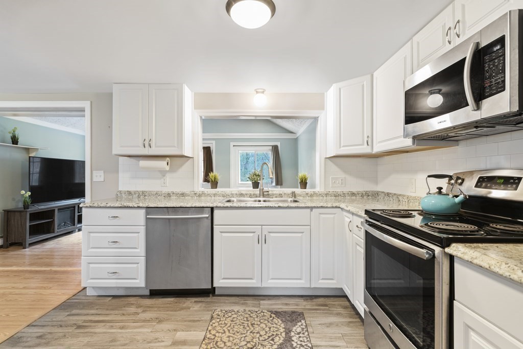 89 Richmond Road Freetown, MA 02702 - Photo 2 of 31 a kitchen with stainless steel appliances granite countertop a stove top oven a sink dishwasher and white cabinets with wooden floor