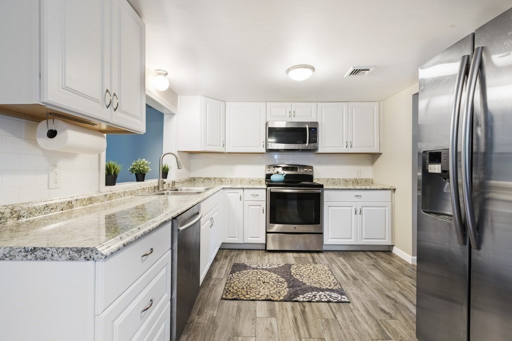 89 Richmond Road Freetown, MA 02702 - Photo 3 of 31 a kitchen with kitchen island granite countertop stainless steel appliances and wooden cabinets