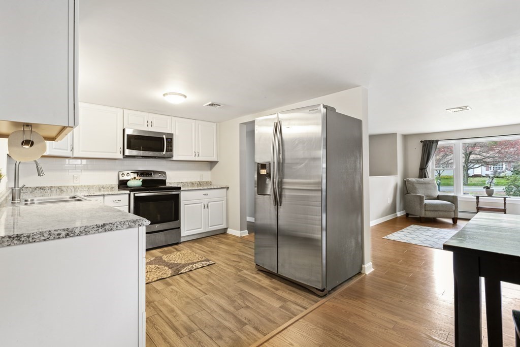 89 Richmond Road Freetown, MA 02702 - Photo 4 of 31 a kitchen with stainless steel appliances granite countertop a refrigerator a stove a sink a dining table and chairs