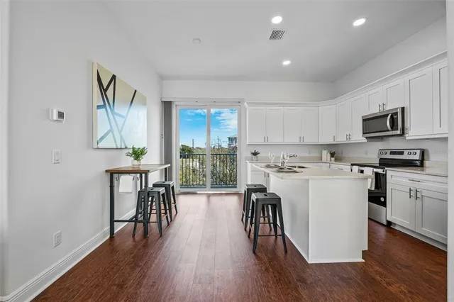 a kitchen with a table chairs refrigerator and a table