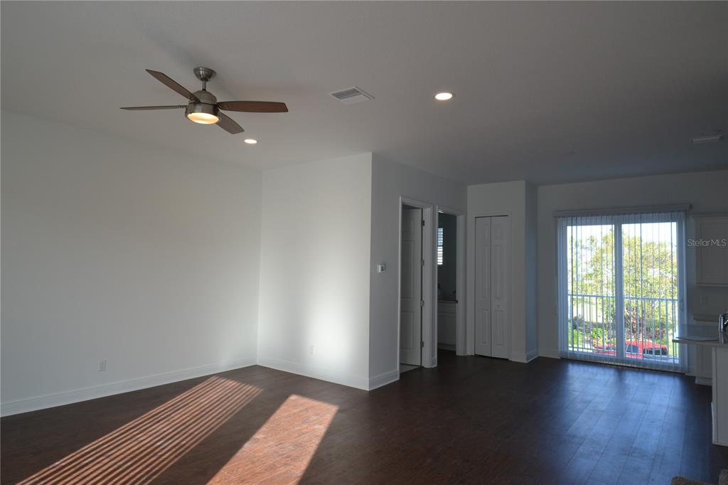 5730 Biscayne Court New Port Richey, FL 34652 - Photo 21 of 35 an empty room with wooden floor fan and windows