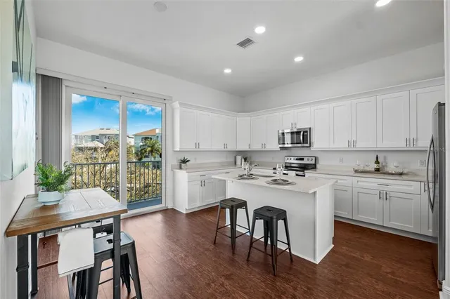 a kitchen with white cabinets stove and refrigerator