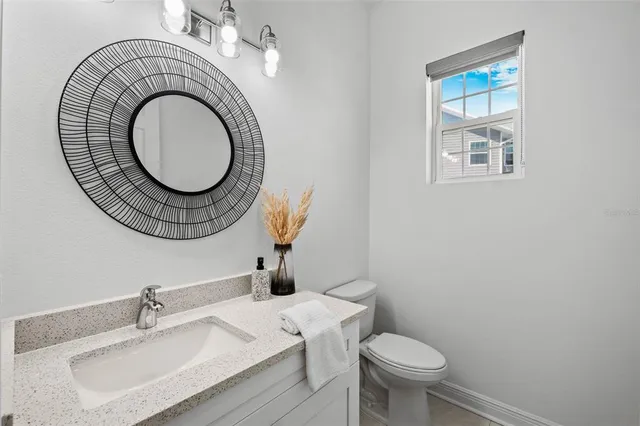a bathroom with a sink a toilet and a mirror