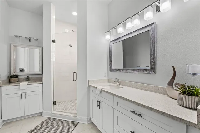 a bathroom with a sink a large mirror and a shower