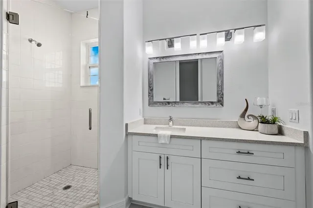 a bathroom with a shower sink and mirror