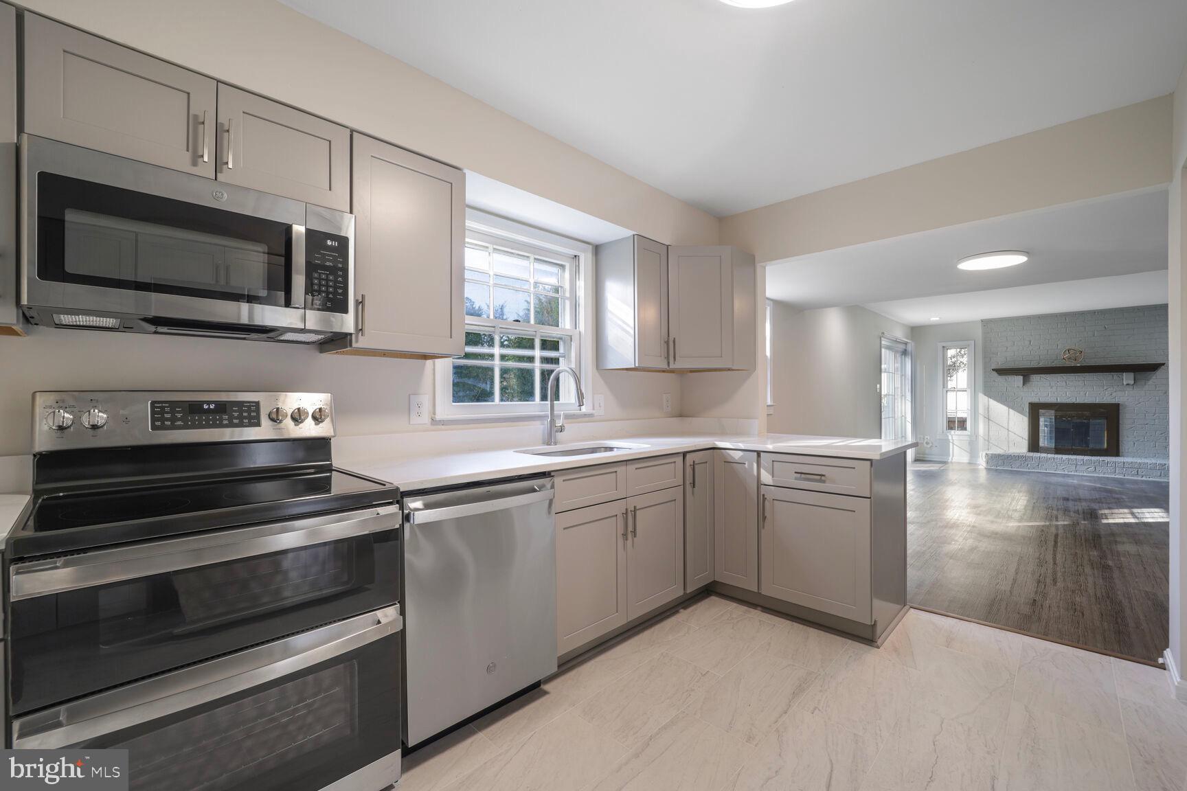 13802 Poplar Tree Road Chantilly, VA 20151 - Photo 13 of 61 a kitchen with stainless steel appliances a stove microwave and sink