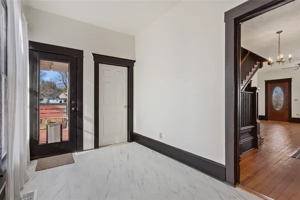 a view of a hallway with wooden floor and dining room