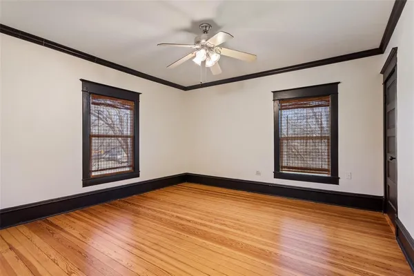 a view of an empty room with window and wooden floor