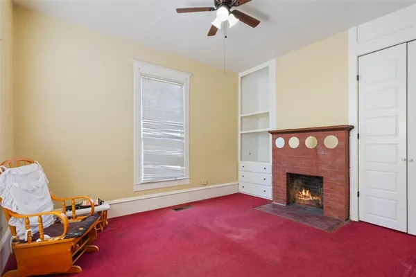 a livingroom with a fireplace and window