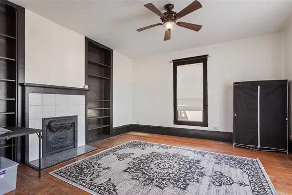 an empty room with windows and fireplace