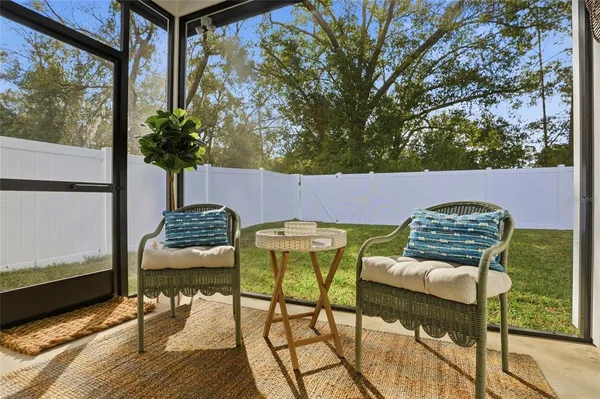 a patio table and chairs with potted plants