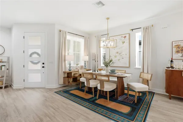 a living room with furniture a large window and a dining table