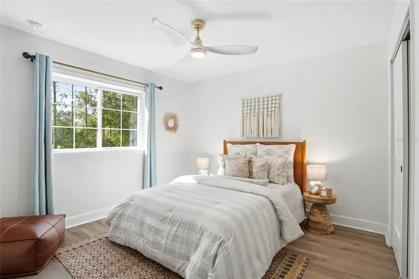 a bedroom with a bed rug and wooden floor