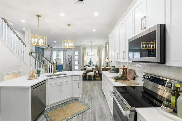 a kitchen with stainless steel appliances kitchen island granite countertop a stove and a view of living room with a fireplace