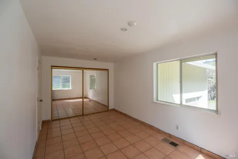 an empty room with windows and closet