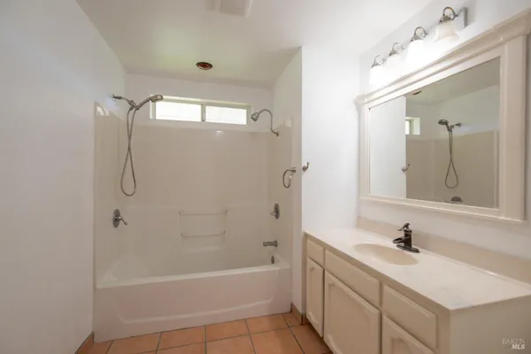 a bathroom with a tub sink and mirror