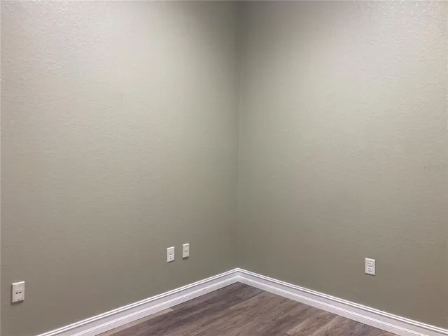 a view of a small space with wooden floor and a window