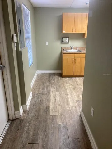 a view of a kitchen with wooden floor and a sink