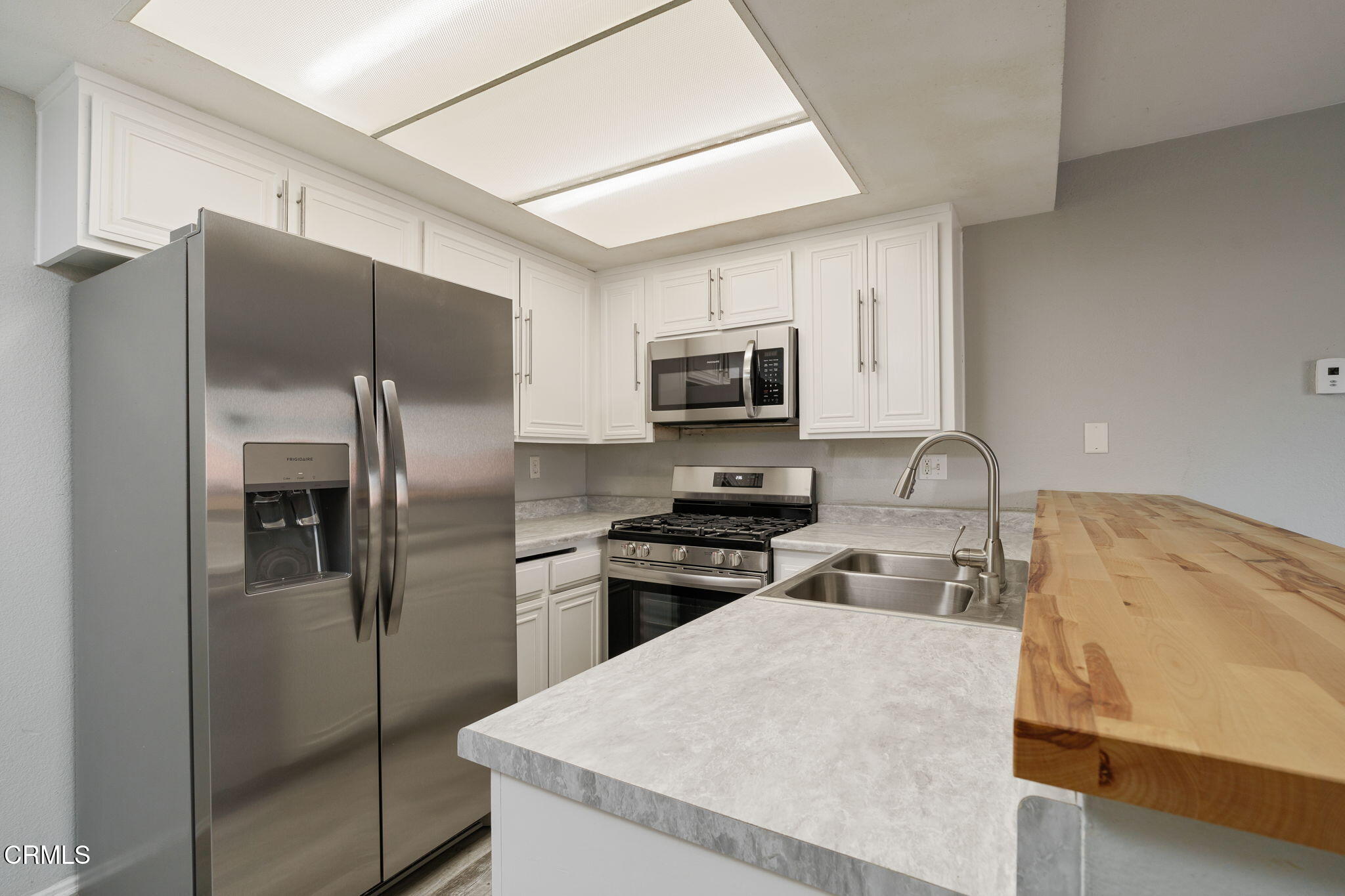 4526 Saviers Road Oxnard, CA 93033 - Photo 8 of 20 a kitchen with refrigerator a microwave a stove and cabinets