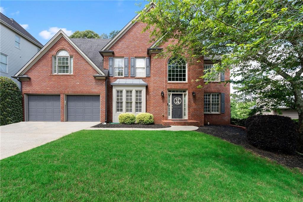 7053 Hunters Ridge Woodstock, GA 30189 - Photo 1 of 1 a front view of a house with a yard and trees