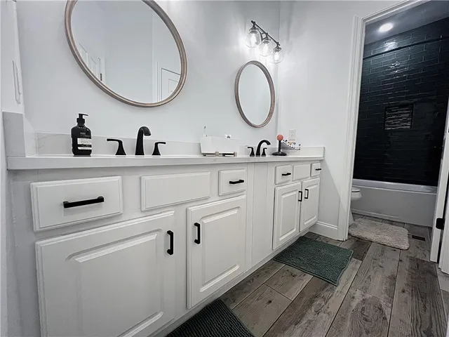 a bathroom with a double vanity sink and a mirror