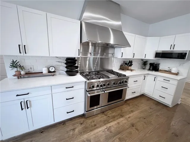 a kitchen with white cabinets stainless steel appliances and sink
