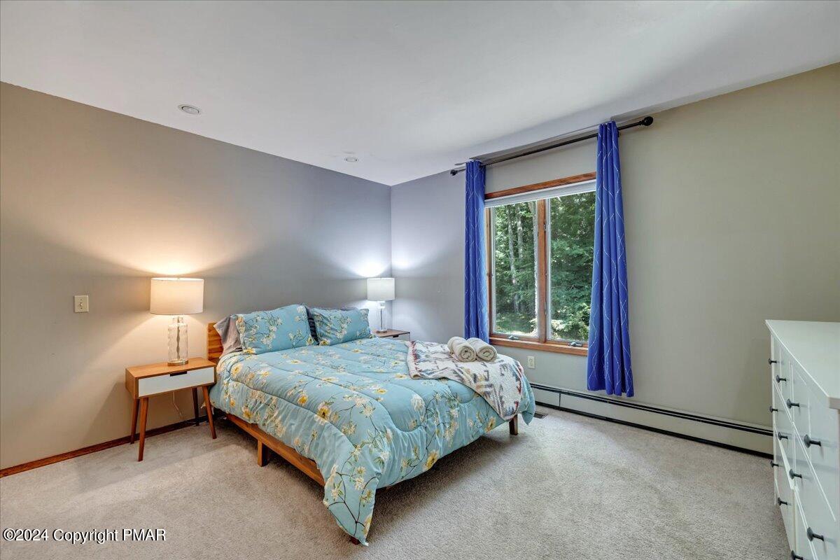 401 Minsi Trail West Long Pond, PA 18334 - Photo 27 of 34 a bedroom with a bed lamp and a large window