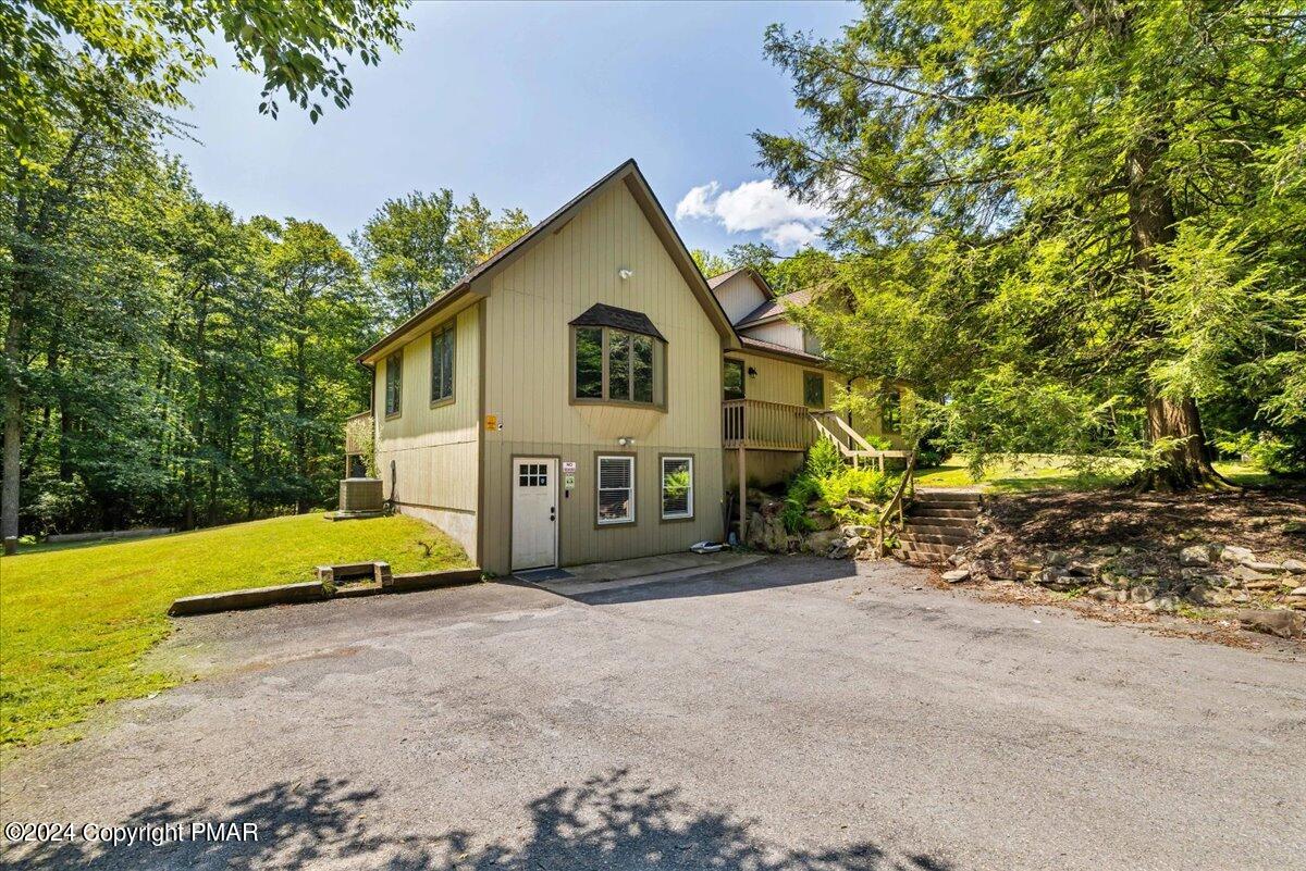 401 Minsi Trail West Long Pond, PA 18334 - Photo 3 of 34 a view of backyard with a table and chair under an umbrella