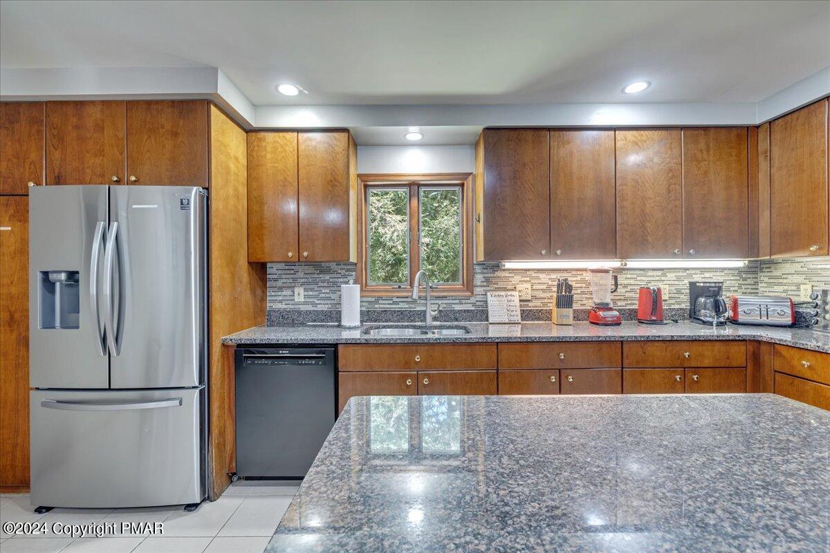 401 Minsi Trail West Long Pond, PA 18334 - Photo 10 of 34 a kitchen with stainless steel appliances granite countertop a refrigerator a sink and a stove