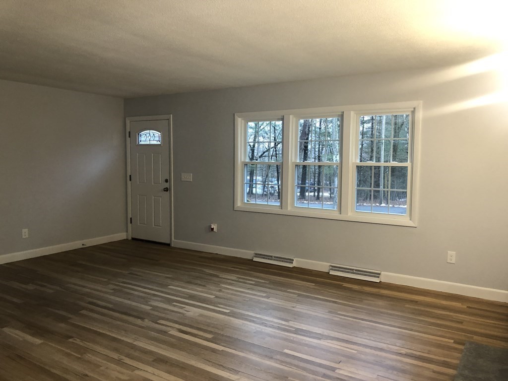 39 Stone School Road Sutton, MA 01590 - Photo 8 of 14 a view of an empty room with wooden floor and a window