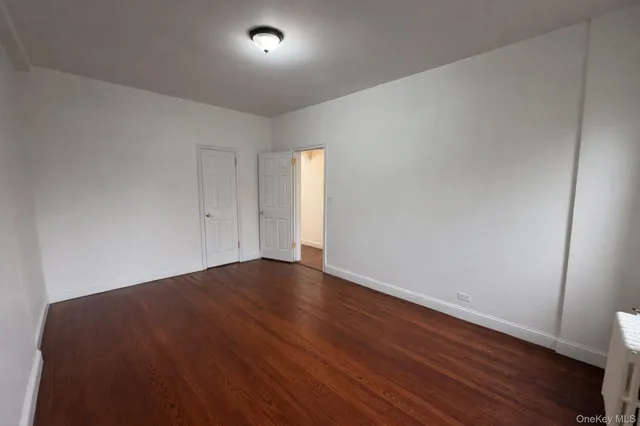 an empty room with wooden floor and window