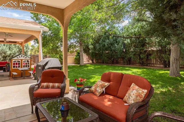 a view of backyard with outdoor seating and green space